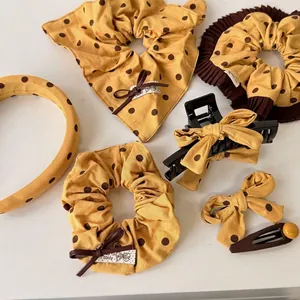Ginger yellow polka dot hair accessories set with scrunchies and headband on white backdrop