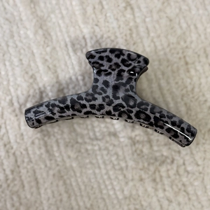 Detailed close-up of grey leopard print hair claw clip with glossy acrylic finish