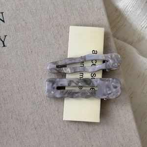 Detailed macro view of purple acetate hair clips set with elegant marble texture and waves