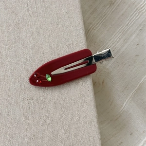 Dettaglio della clip per capelli rossa in acetato con ciliegie decorate con strass lucidi