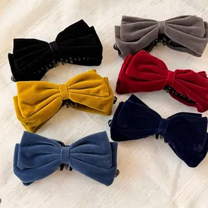 Lot de six pinces à cheveux en velours avec nœuds en couleurs variées sur tissu