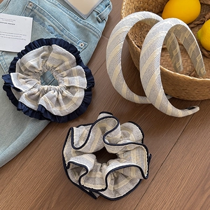 Set of four striped fabric scrunchies and headbands on rustic wooden background