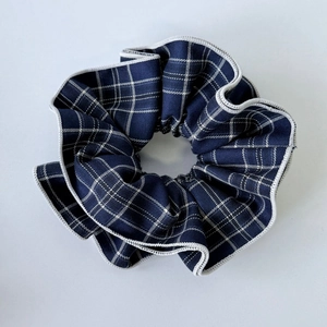 Detailed close-up of dark blue plaid scrunchie with crisp white checked patterns