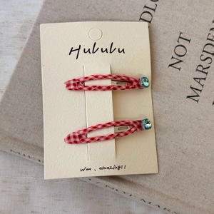 Paire de barrettes à carreaux rouges et blancs avec strass bleus sur carte support