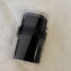 Macro shot of durable black braided elastic hair ties in a clear cylindrical jar