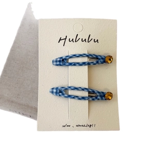 Paire de barrettes BB à carreaux bleus avec strass jaunes sur carte de présentation
