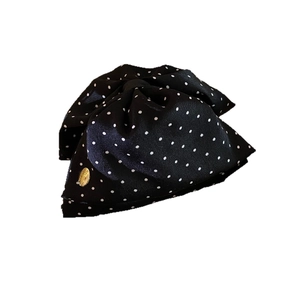 Elegant black polka dot bow hair claw with satin texture and gold metallic charm
