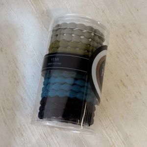 Detail view of wavy textured elastic hair ties in Morandi colors and transparent tube