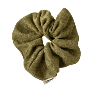 Elastico per capelli verde oliva in maglia luccicante con etichetta bianca di marca