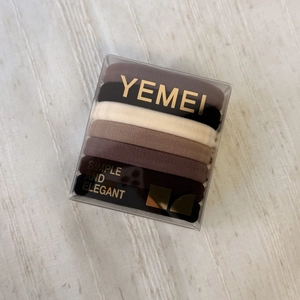 Set of 8 elastic seamless hair ties in neutral brown tones within a square box
