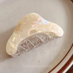 Close-up of cream acetate claw clip with pearl marble texture and Barrette La France text