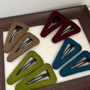 Close-up of wool texture triangle hair clips in brown, burgundy, green and blue