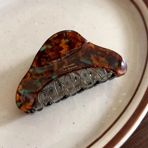 Close-up of tortoise shell pattern cellulose acetate hair claw with Barrette La France text