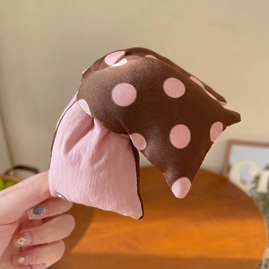 Détail de la pince à cheveux en coton gaufré avec motif à pois contrastés