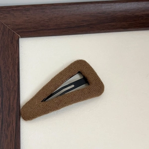 Detailed close-up of brown knit wool fabric texture on triangular BB hair clip