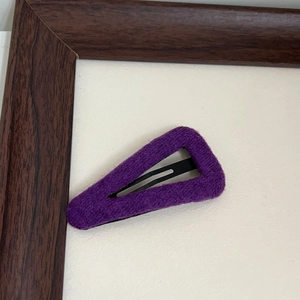 Detailed view of purple felt fabric texture on a minimalist triangular metal hair clip