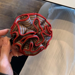 Detail view of the red plaid floral pattern fabric and fine stitching on the banana hair clip