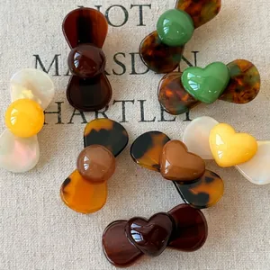 Mini resin hair clips with heart and butterfly shapes in amber and tortoiseshell finish