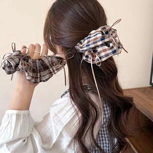Plaid scrunchies with ribbon bows for women, showing brown and blue checkered fabric patterns