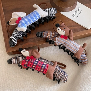 Cartoon dachshund hair clips in blue, brown and red plaid styles on a wooden tray