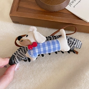 Detail of cute dachshund plush hair clip featuring blue plaid shirt and houndstooth fabric