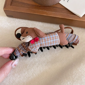 Detailed view of plush brown dachshund hair claw with blue plaid pattern fabric