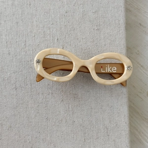 Detail of cream marble acetate hair clip with rhinestones and Like engraving