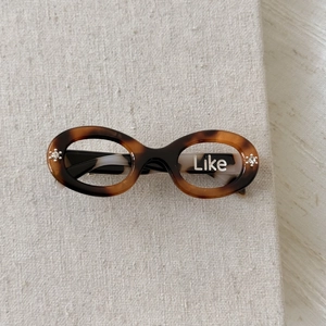 Detail of tortoise shell hair clip with crystal flowers and Like lettering inlay