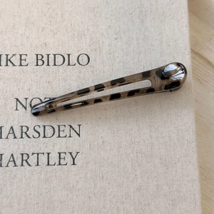 Close-up of translucent leopard print hair clip with tortoiseshell texture on fabric base