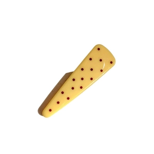 Chic yellow hair clip with red polka dots and brown base for minimalist styling