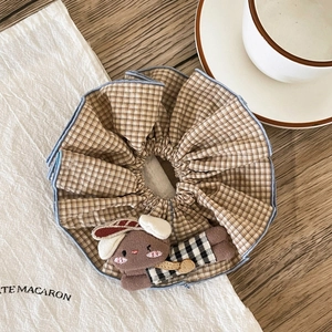 Detail of checkered hair scrunchie with cute brown plush rabbit doll and blue edge stitching
