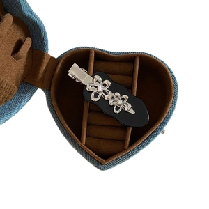 Metallic flower hair clip with silver blooms on black plate in a denim heart gift box