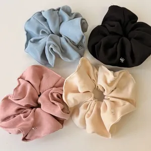 Elegant knit scrunchies set in four soft colors with premium round metal accents