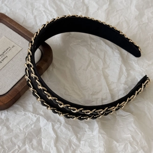 Detail of Hepburn style black leather headband with double gold metal chain links decor