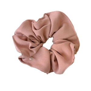 Pink large scrunchie in ribbed knit fabric with a small silver metal logo tag charm