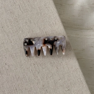 Close-up of tortoise shell acetate hair comb with sparkling rhinestones on linen