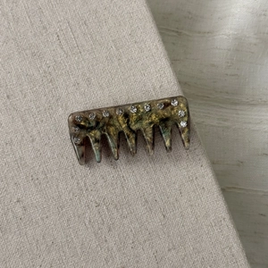 Close-up of retro marble acetate hair clip with sparkling inlaid rhinestones