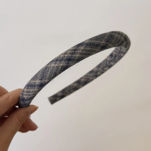 Détail d'un serre-tête en tissu à carreaux bleus avec texture plissée élégante et rembourrée