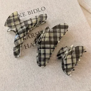 Three sizes of plaid acetate hair claw clips with classic black and white checkered pattern