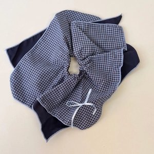 Detail of blue plaid layered bow hair scrunchie with delicate white ribbon and stitching