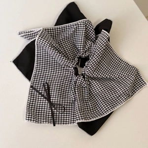Detail of the black and white gingham fabric texture and small bow on hair accessory