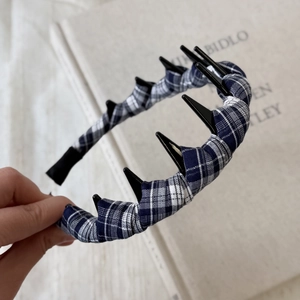 Close-up of blue and white plaid fabric headband with black plastic hair comb teeth detail