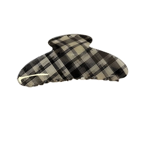 Classic black and white checkered hair claw clip with yellow logo on white background