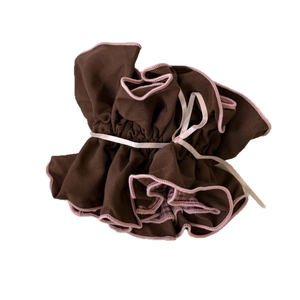 Brown fabric drawstring pouch with pink ruffled edges and satin ribbon closure