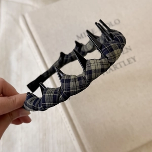 Detail of blue and gray plaid fabric headband with dual-layer hair clips for styling
