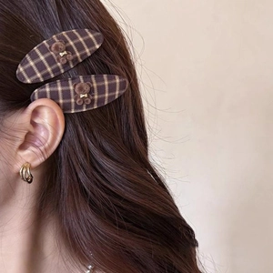 Detail of cute flocked bear hair clips with brown plaid fabric on brown hair
