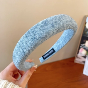 Detailed view of light blue knitted headband texture with hand made label detail