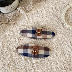 Detail of plaid fabric BB hair clips with cute 3D flocked bears and golden bows