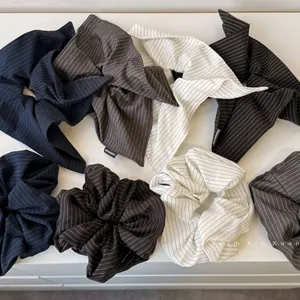 Detailed macro of handmade striped scrunchies and bow hair ties in various classic colors