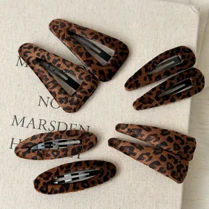 8-piece vintage leopard print hair clip set in various shapes on a soft fabric book